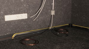 Kabelkanäle als Sockelleiste mit eingelegten Kabeln