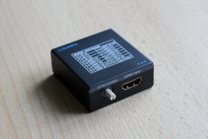 Ein HDMI EDID Manager: schwarzer Kasten mit je einem HDMI-Ein- und Ausgang sowie einem Schalter zur Wahl des unterstützen Signals.